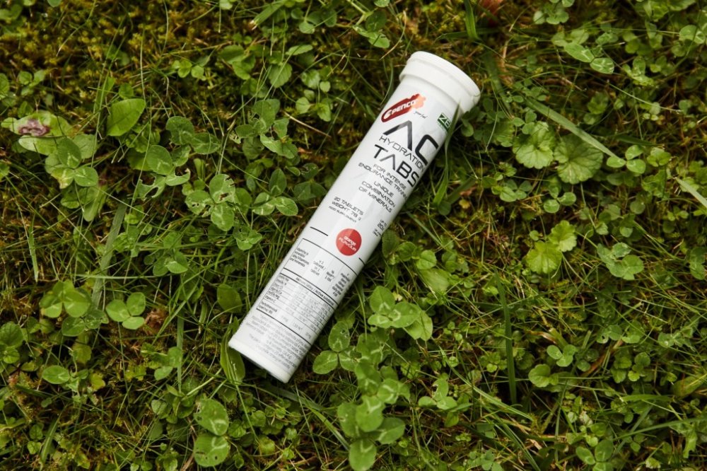Produkt AC Hydration Tabs leží na trávě.