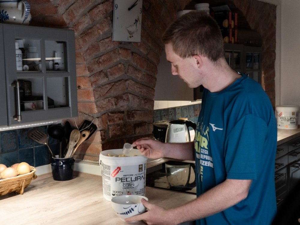 Mladý muž si doma v kuchyni připravuje Penco kaši Pelupa.