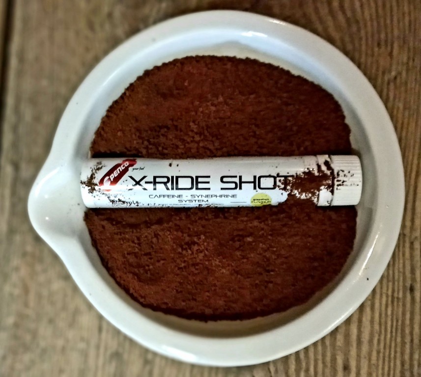 Penco X-Ride Shot položený v šálku s namletou kávou.