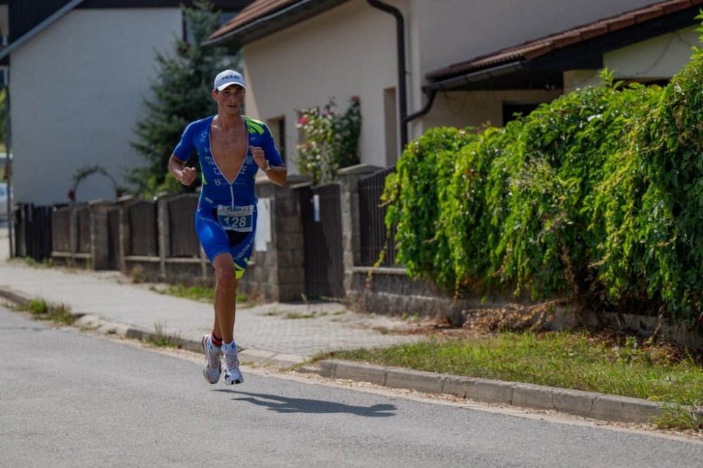 Jakub Stádník běží v dresu s číslem 128 po silnici
